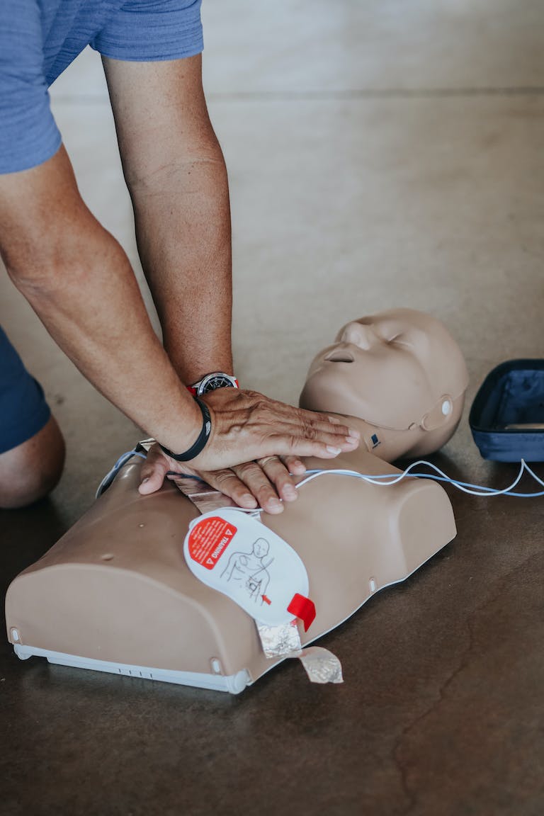 Hands of Person Doing CPR on Training Dummy