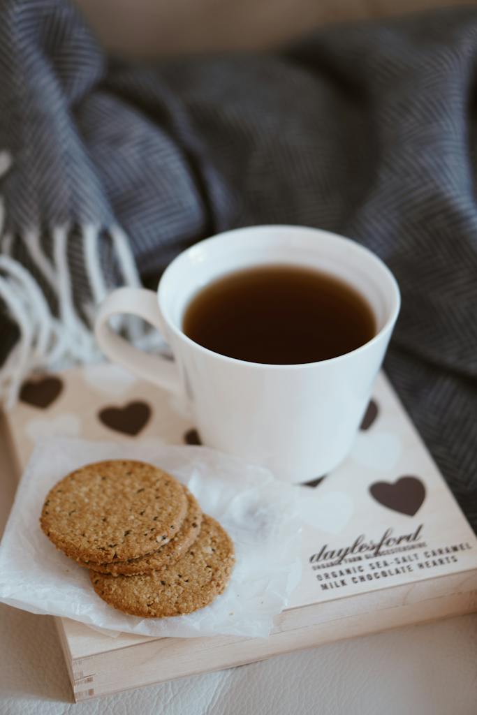 White Ceramic Coffee Cup Beside Biscuits