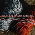 Close-Up Shot of Knitting Needles and Yarn Rolls