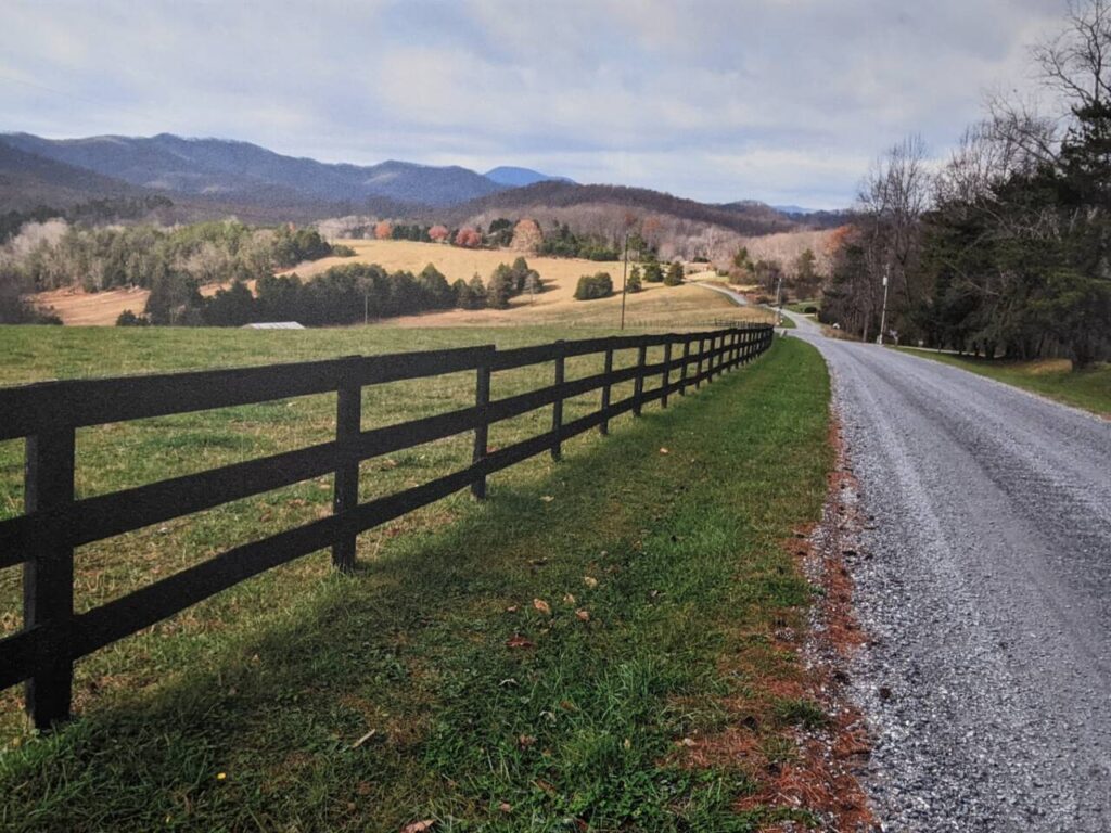 scene featuring a gravel country road leading toward distant mountains.