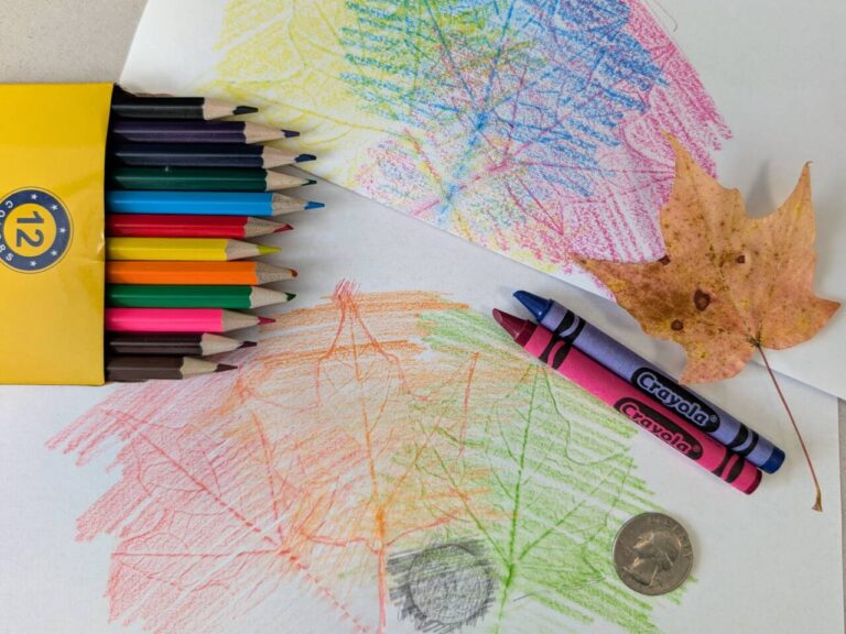 colorful pencils and crayons on top of a rubbed drawing.