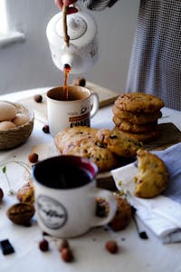 Pouring Tea on Table with Cookies