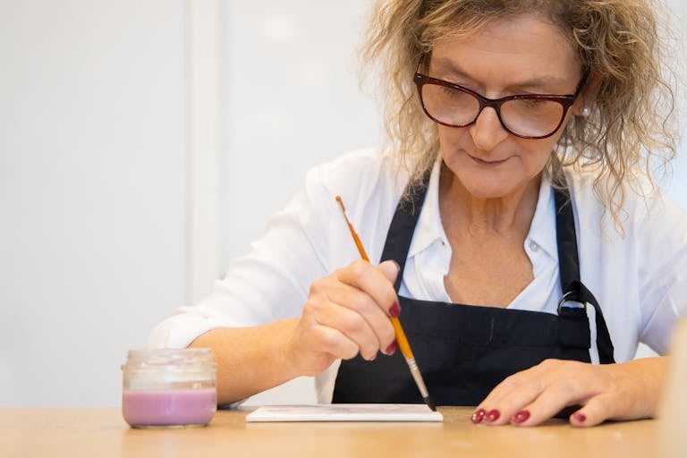 Focused elderly woman painting