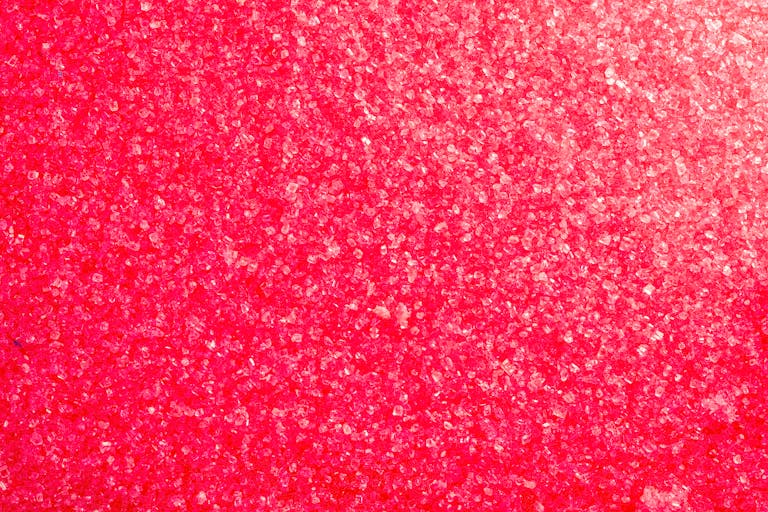 Close-up of vibrant pink crystals forming a textured background.