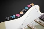 Close-up of colorful guitar picks on an electric guitar.