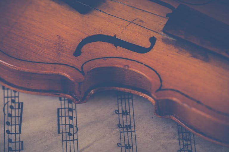 Artistic close-up of a violin on sheet music, highlighting musical elegance.