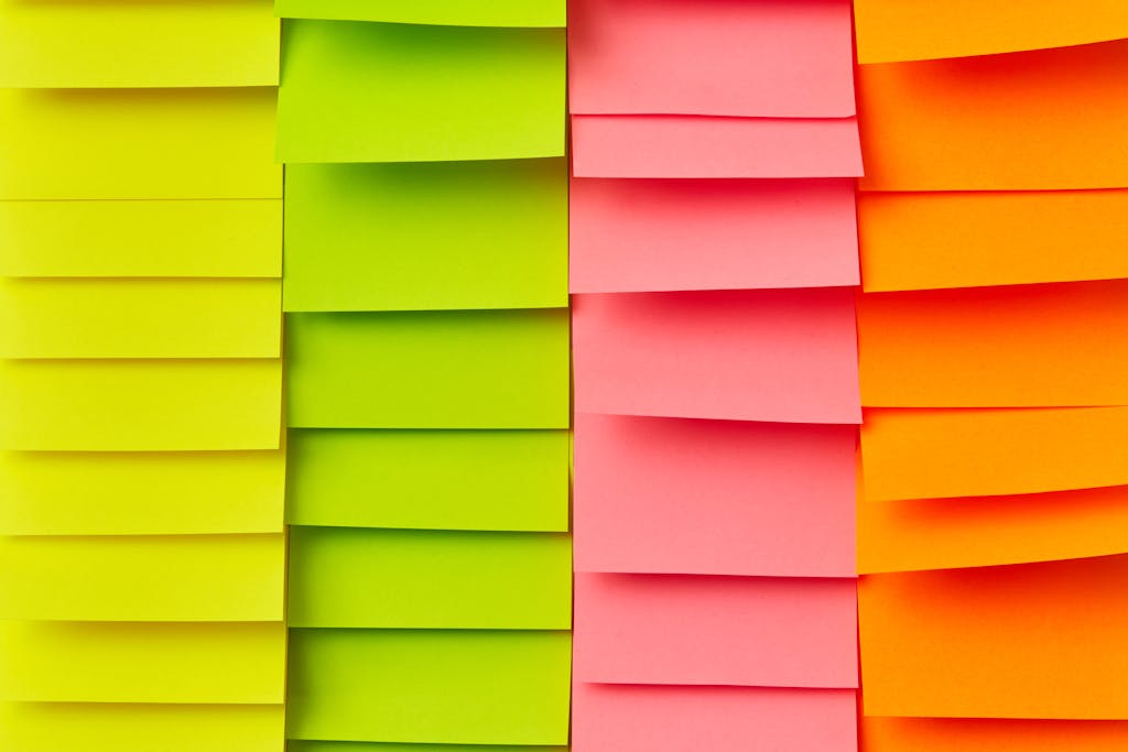 Colorful sticky notes arranged neatly creating a vibrant wall texture for creative backgrounds.