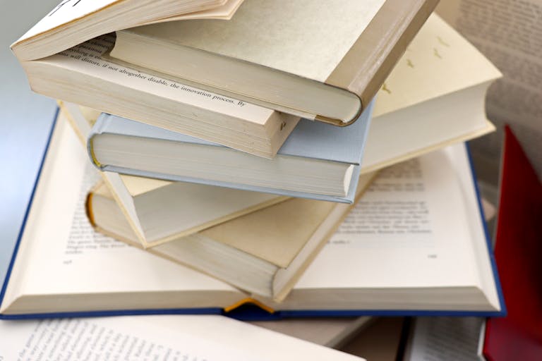 A disorganized stack of open and closed books showcasing education and study themes.