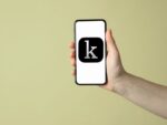 Hand holding mobile phone with Kanopy app icon on phone screen