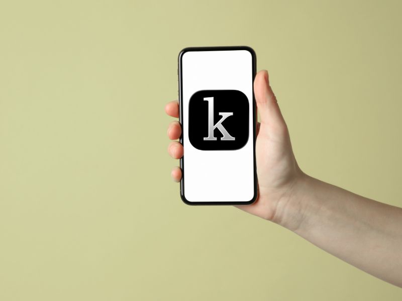 Hand holding mobile phone with Kanopy app icon on phone screen