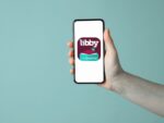 Hand holding mobile phone with Libby app icon on phone screen