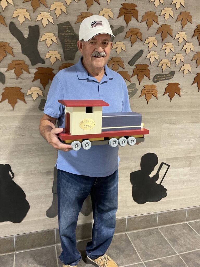 Artist Nick Anthony Orlando holding his Spirit of '76 railcar