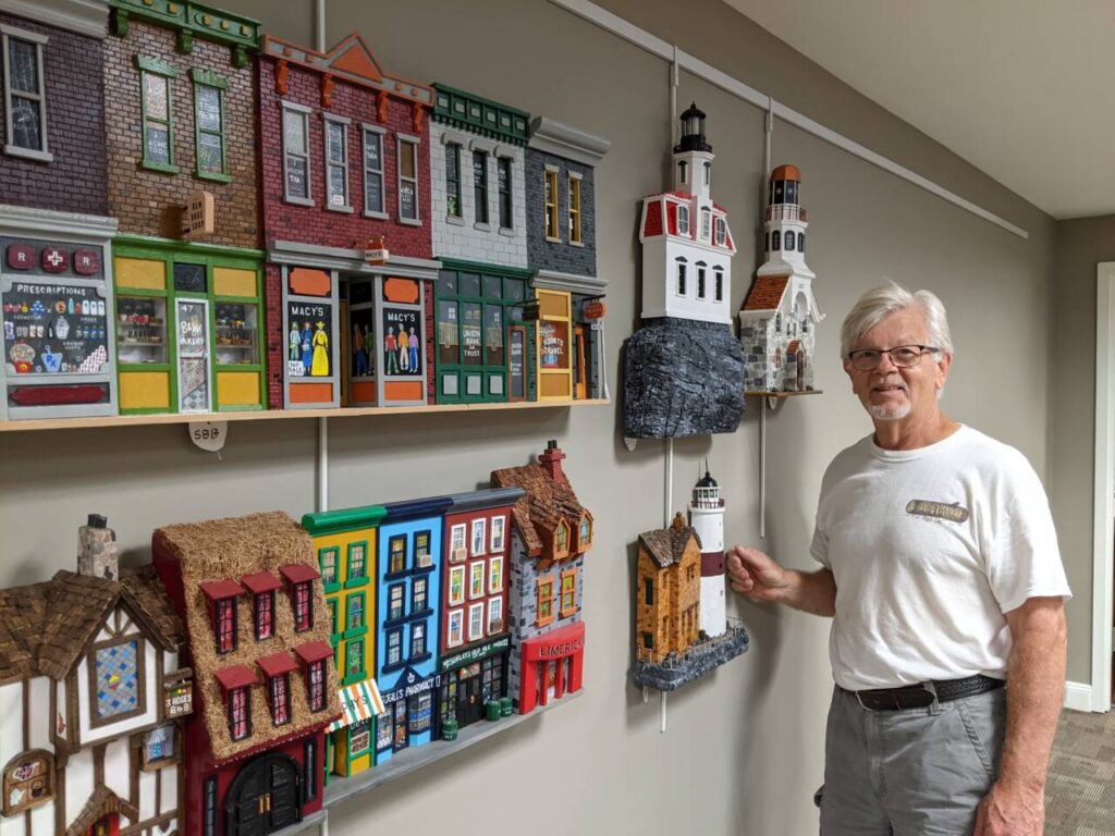 Artist Rick Wieser standing next to his woodworking art Pieces